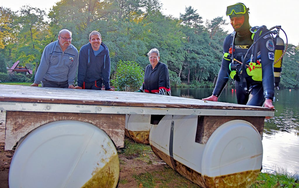 Ein Einsatz der besonderen Art am Steinbruch in Süplingen: Reinhard Giemulla trägt gemeinsam mit seinem Sohn Michael, seiner Ehefrau Christiane und Taucher Timo Weißenfels die Badeinsel aus dem Wasser.