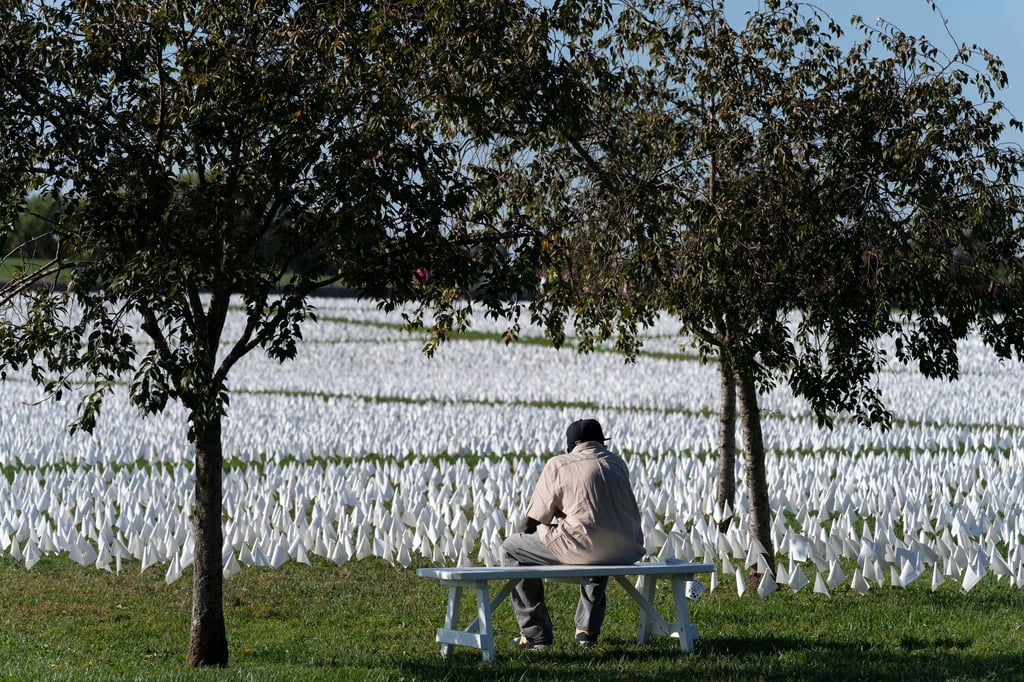 Ein Besucher sitzt auf einer Bank und betrachtet die von der Künstlerin Suzanne Brennan Firstenberg geschaffene Installation „In America: Remember“ in Washington DC. Seit Beginn der Pandemie sind in den USA mehr als 700.000 Menschen nach einer Infektion mit dem Coronavirus gestorben.