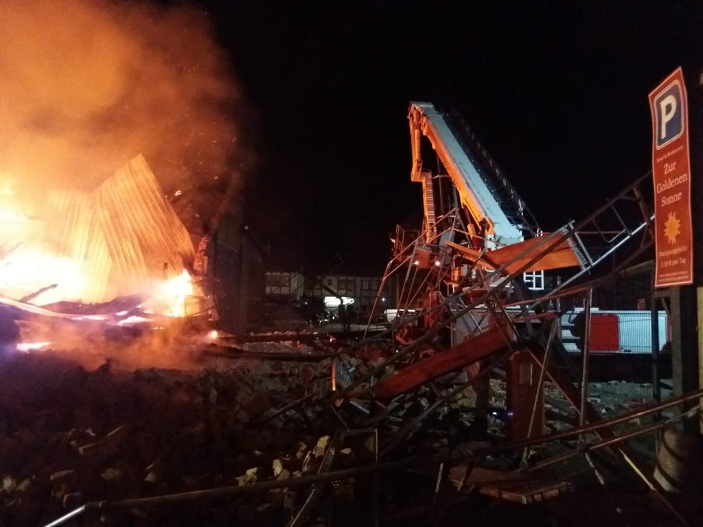 Die Lagerhalle, die in Quedlinburg in Flammen aufgegangen ist, ist zum Teil eingestürzt. Dabei wurde ein Feuerwehrmann unter den Trümmern begraben. Foto: