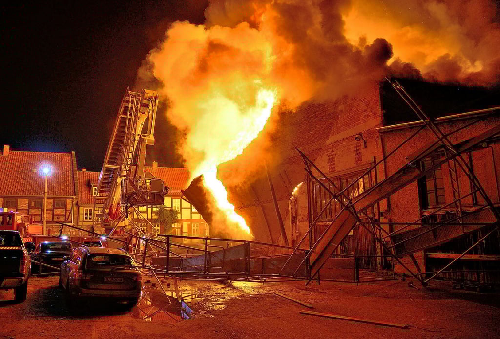 Meterhoch schlagen die Flammen aus der brennenden Lagerhalle im Augustinern. Ein Baugerüst ist umgestürzt, die Mauer stürzt ein.