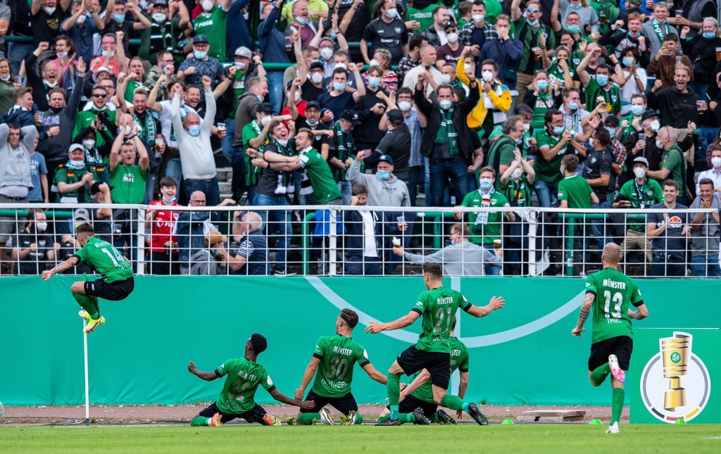 Die Spieler von Preußen Münster jubeln mit ihren Fans.