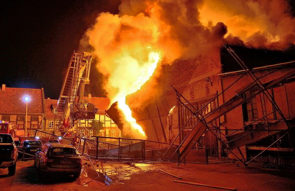 Das Foto macht das Ausmaß des Großbrandes der Lagerhalle im Augustinern in Quedlinburg deutlich: Die Giebelwand wurde bei der Verpuffung herausgedrückt und stürzte das aufgebaute Baugerüst auf das nebenstehende Drehleiterfahrzeug.