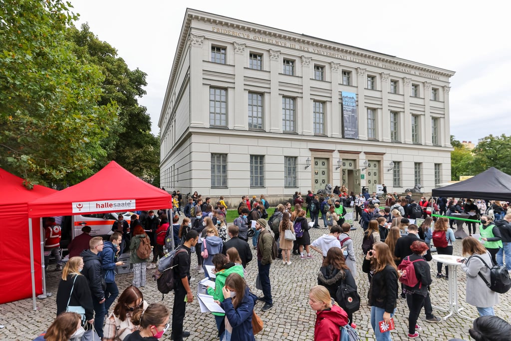 Studenten stehen vor dem Löwengebäude der Uni Halle. Die Hochschule hat am Montag mit einer großen Immatrikulationsfeier 3700 Erstsemester begrüßt.
