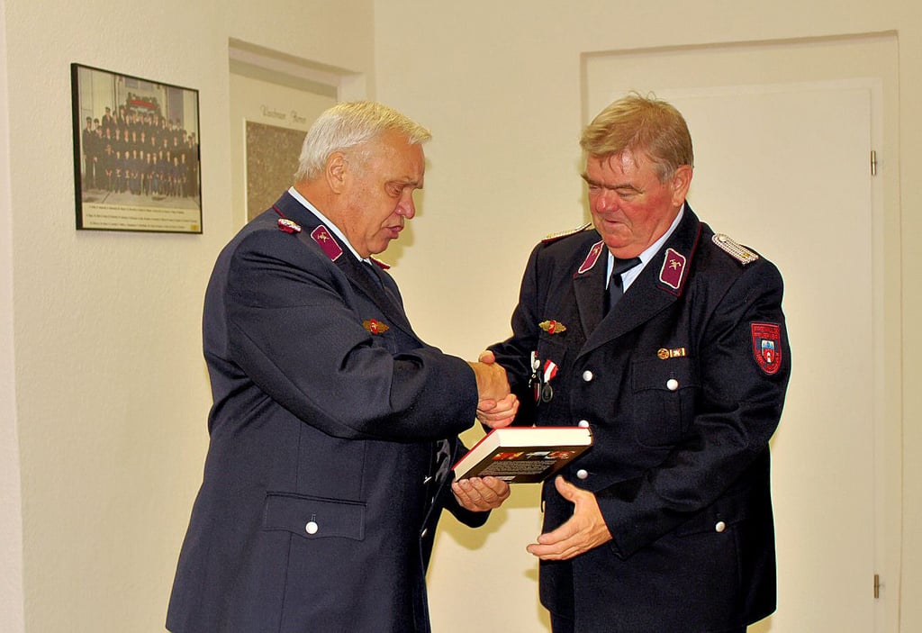 Harald Hinz hatte ein Buch zu historischen Ereignissen in der Feuerwehr mitgebracht und überreichte es Heinz Meyer (rechts).