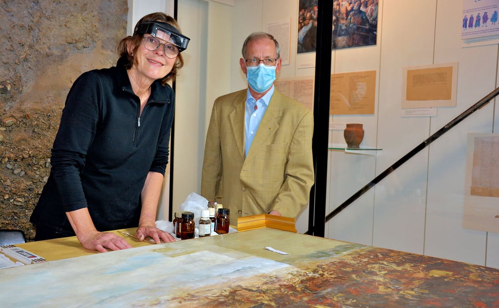 Diplom-Restauratorin Roswitha Dreysse zeigt Volker Bürger, Vorsitzender des Geschichtsvereins Halberstadt, wie weit sie mit der Reinigung und Restaurierung einer Darstellung der Schlacht von Mars-la-Tour, gemalt von Theodor Rocholl, ist.