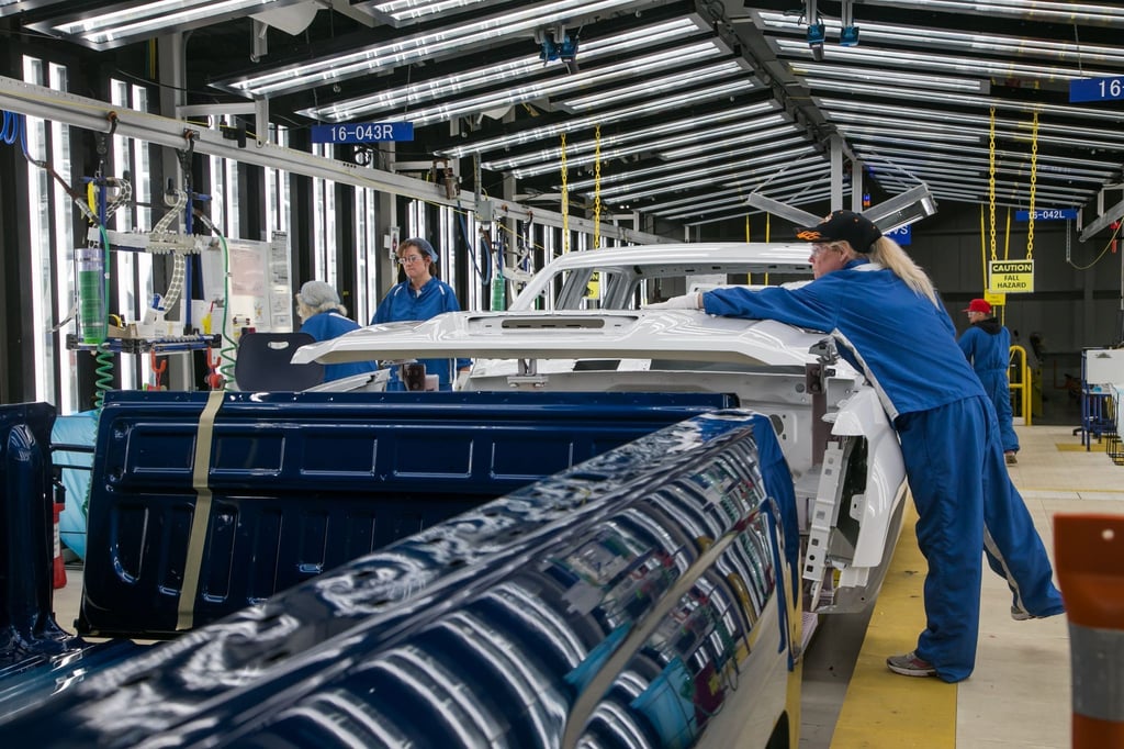 Arbeiter führen in der Lackiererei der General Motors Flint Assembly eine Endkontrolle durch.
