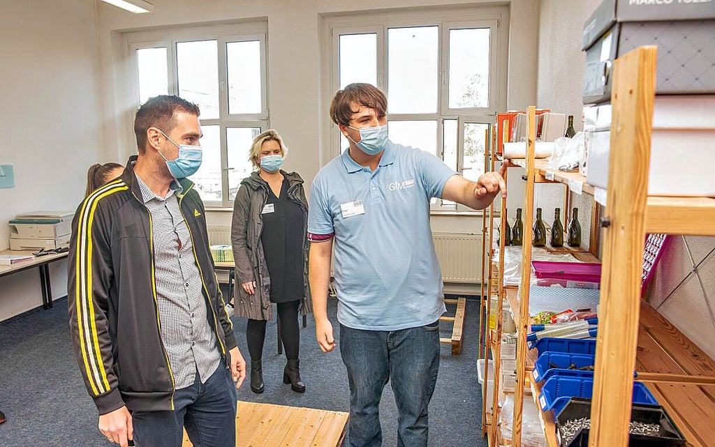 Der Auszubildende Tom Klemens (re.) erklärt Clemens Schlee von der Firma Ernstings Family das Lagersystem.