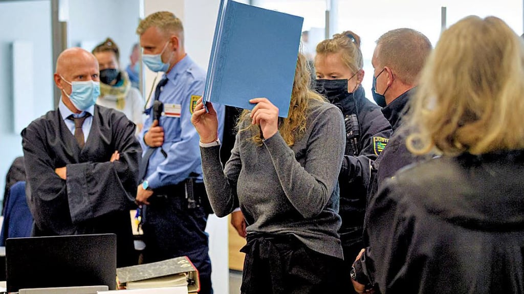 Die Angeklagte Lina E. verbirgt ihr Gesicht, als sie im September vor dem Oberlandesgericht Dresden angeklagt wird.