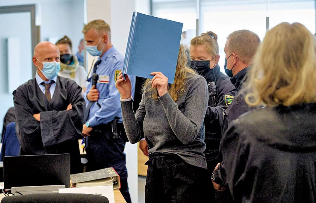 Die Angeklagte Lina E. verbirgt ihr Gesicht, als sie im September vor dem Oberlandesgericht Dresden angeklagt wird.
