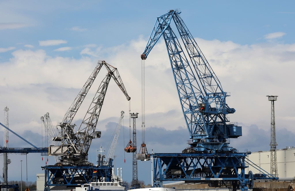 In einem Seehafen an der Ostsee wird ein Schiff mit Kränen abgefertigt.