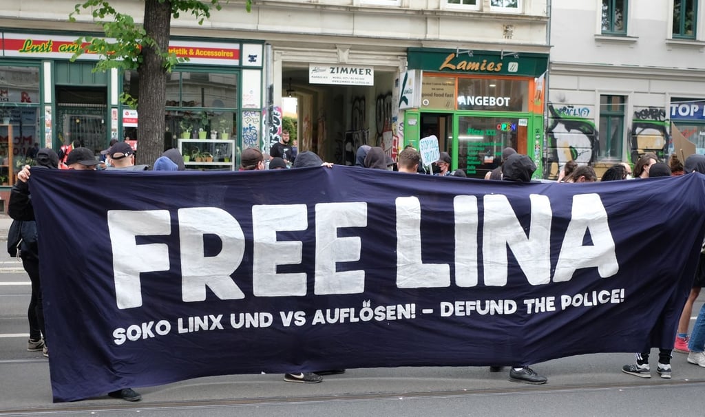 Teilnehmer einer linken Demonstration versammeln sich im Stadtteil Connewitz und tragen ein Transparent mit der Aufschrift „Free Lina“.