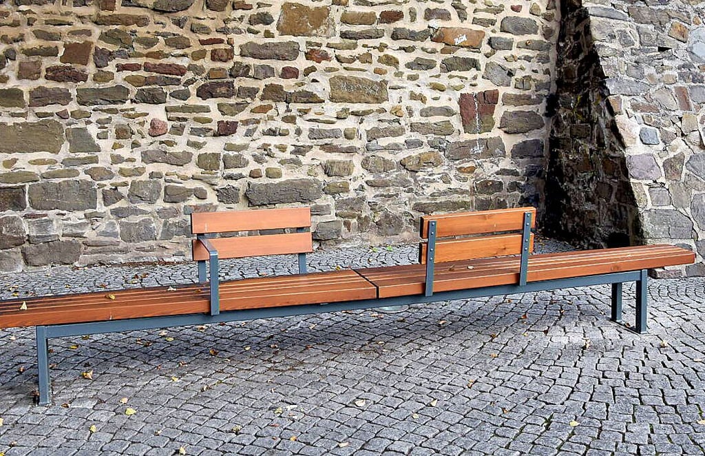 Die Lehnen zweier Bänke am Hagentorplatz, die teils auf die Stadtmauer zeigen, sollen einheitlich auf den Platz gerichtet werden.