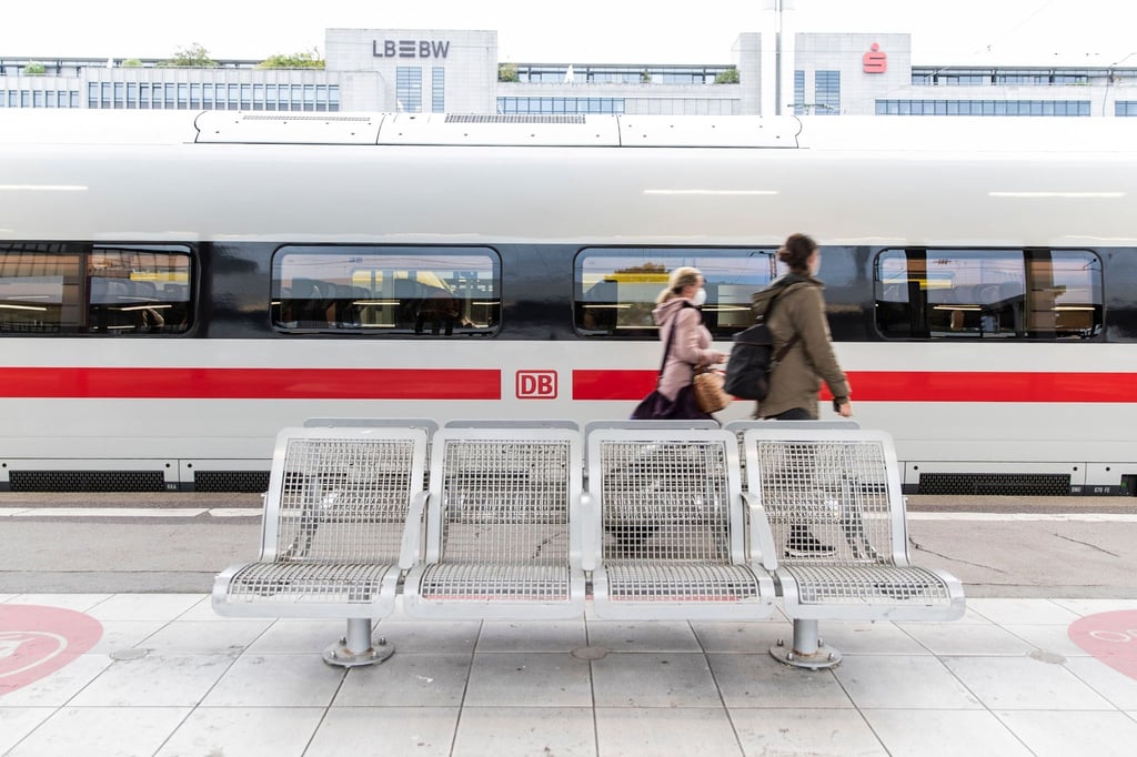 Zwei Frauen gehen am Bahnhof an einem ICE vorbei.
