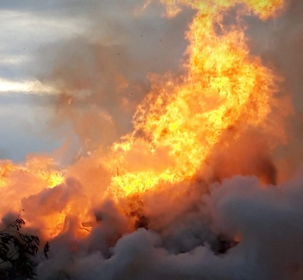 Hoch lodern die Flammen des Herbstfeuers über dem Sportplatz in Gübs.