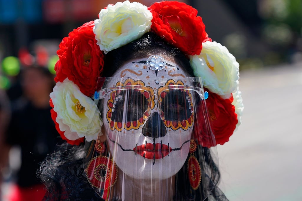 Eine als „Catrina“ verkleidete Frau trägt während der Feierlichkeiten zum Tag der Toten ein Gesichtsschild. Der Día de Muertos in Mexiko ehrt verstorbene Angehörige.