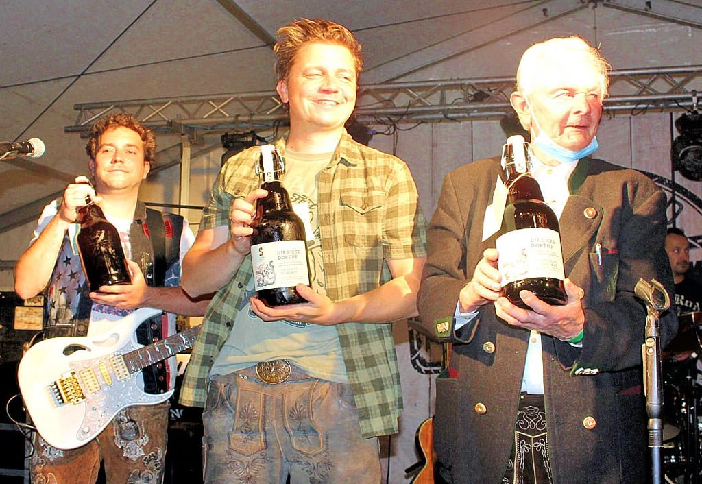 Fanfarenzugleiter Heinz Rudel (rechts) übergab die Bierflasche „Dicke Dörthe" aus Tangermünde an die Dorfrocker.