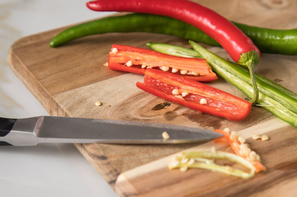 Wie scharf eine Chilischote ist, hängt vom Capsaicin-Gehalt der jeweiligen Sorte ab. Besonders viel von dem Scharfmacher befindet sich in den weißen Rippen, an denen die Kerne hängen.