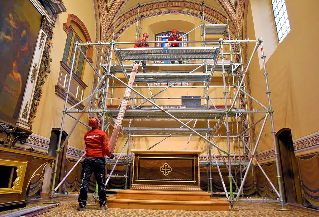 Vorsichtig bauen Handwerker das Gerüst im Altarraum von St. Agnus ab, schließlich soll die gestrichene Wand unversehrt bleiben.