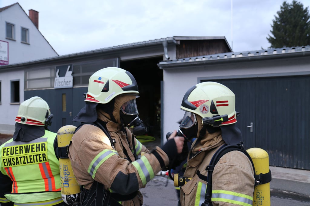 Einsatzkräfte der Bad Kösener Feuerwehr rüsten sich mit Atemschutz aus.