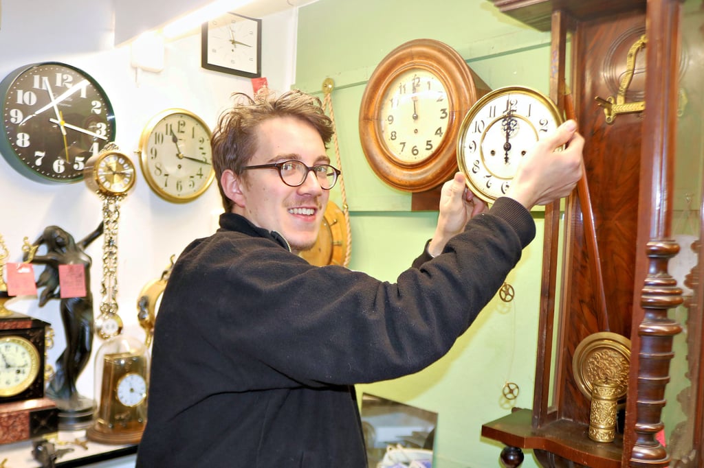 Uhrmachergeselle Carl Robra entnimmt in der Werkstatt von Günther Haut in Seehausen einer Wanduhr das Zifferblatt zur Reparatur.
