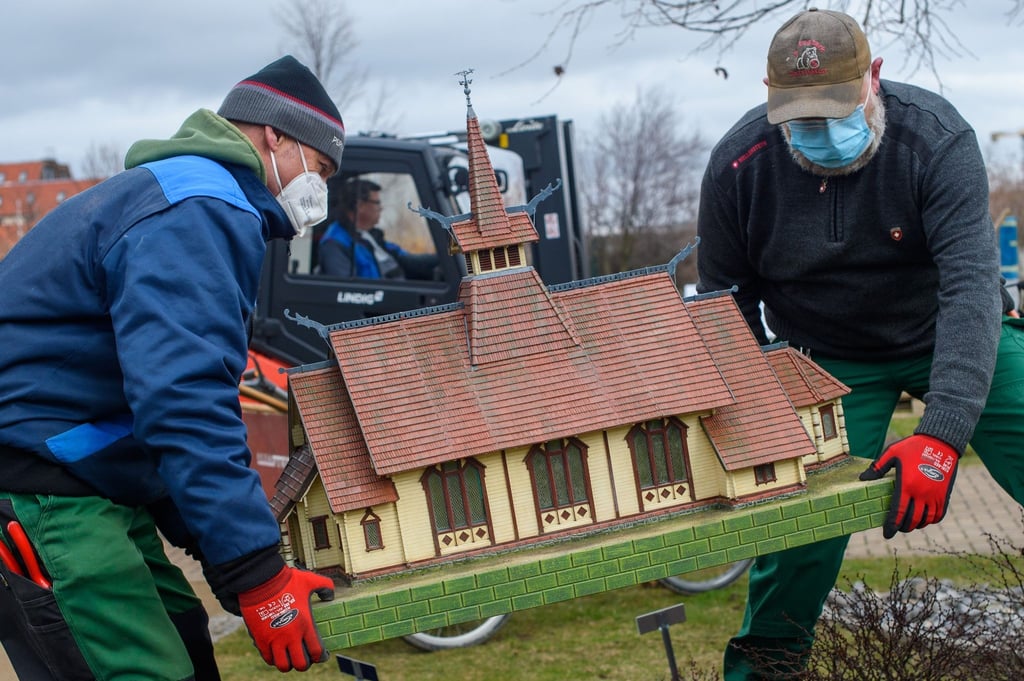 Mitarbeiter des Bürger- und Miniaturenparks Wernigerode stellen das Modell der Stabkirche Stiege an ihren Platz.