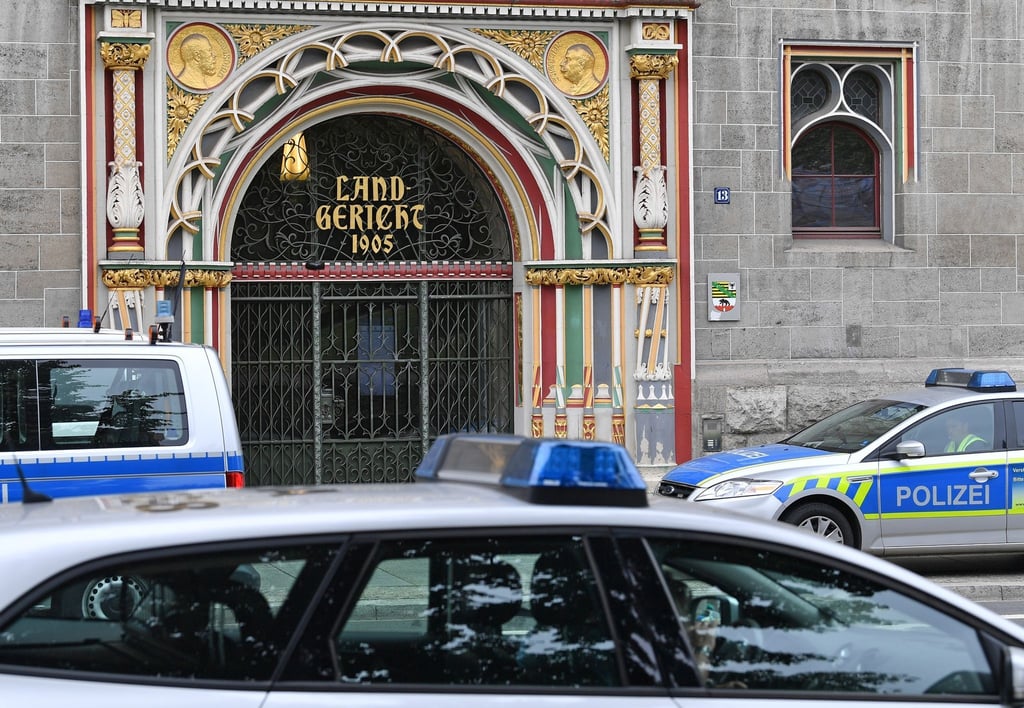 Polizeifahrzeuge stehen vor dem Landgericht in Halle/Saale.