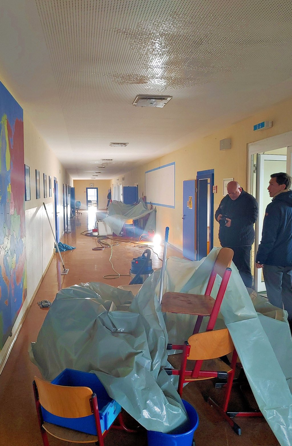 Aus der Decke läuft das Regenwasser. Oberbürgermeister Daniel Szarata (rechts) ist entsetzt über den Schaden am Schulgebäude.