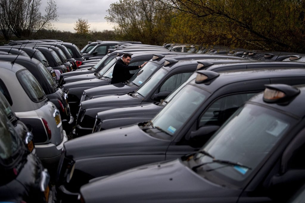 Dutzende während der Corona-Pandemie stillgelegte Taxis, die für London typischen „Black Cabs“, parken auf einer Freifläche.
