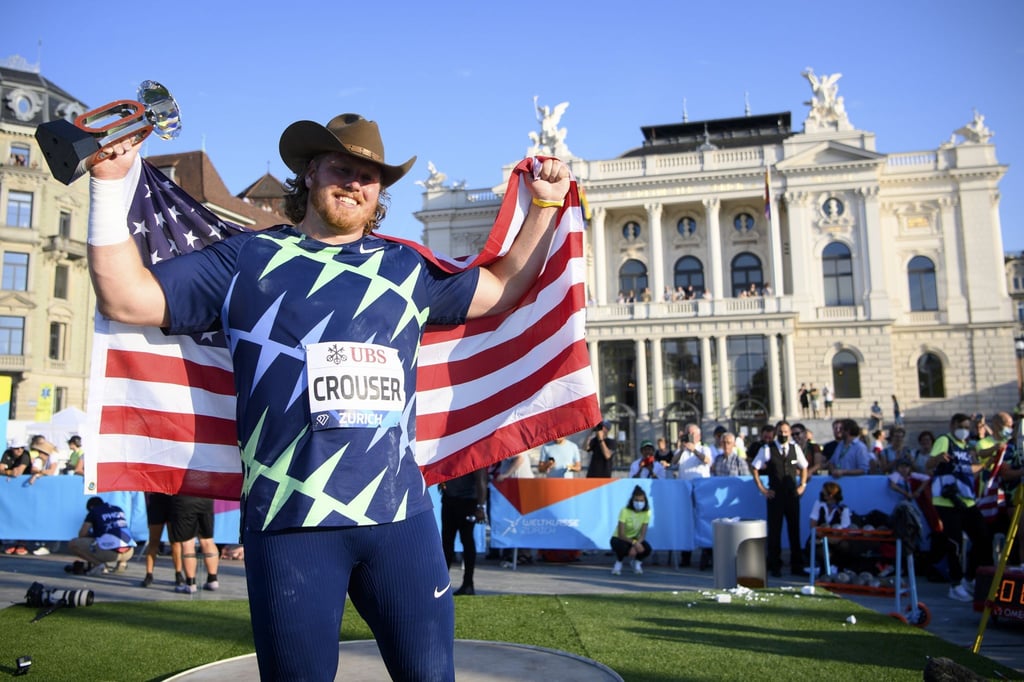 Ryan Crouser aus den USA hält seine Siegertrophäe in der Hand und feiert den ersten Platz.