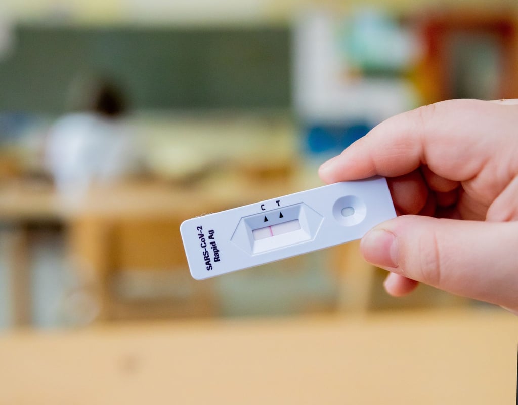 Ein Schüler hält einen negativen Corona-Schnelltest in der Hand.