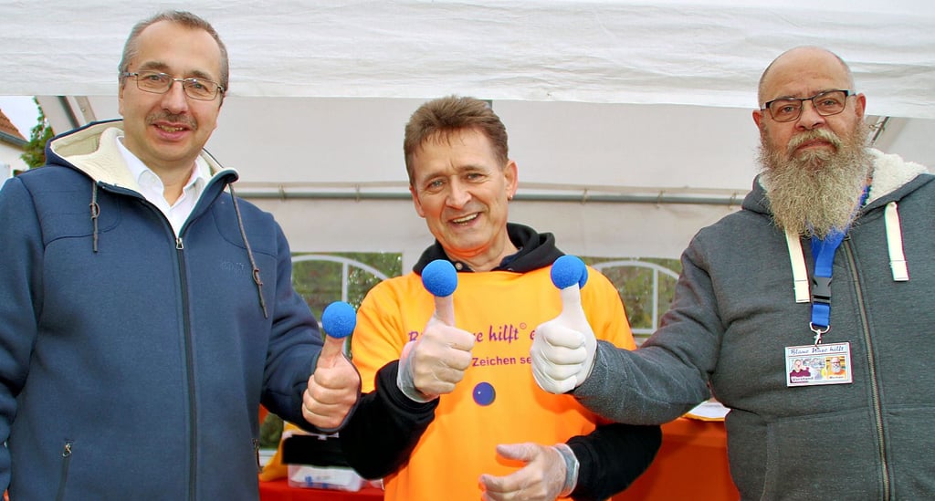 Vereinssprecher Roger Altenburg mit Verbandsgemeindebürgermeister Thomas Schmette (links) und dem ehrenamtlichen Mitarbeiter des Vereins "Blaue Nase hilft", Michael Blume-Kühnast (rechts) auf dem Martinsmarkt in Colbitz.