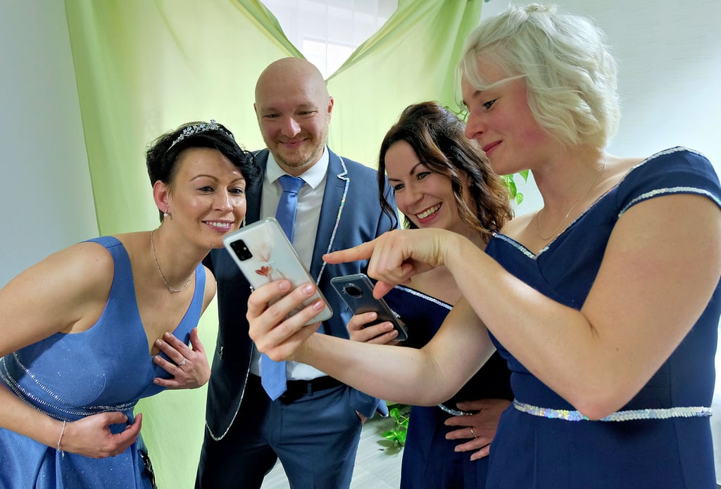 Bevor Juliane (links) und Enrico Kutscher sowie Lisa Wehner (rechts) und Sandra Hahn vor das Rathaus treten, schauen sie sich erste Selfies an.