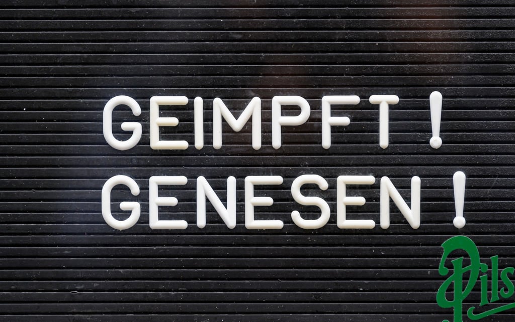 „Geimpft! Genesen!“ steht auf einem Schild an einer Bar.