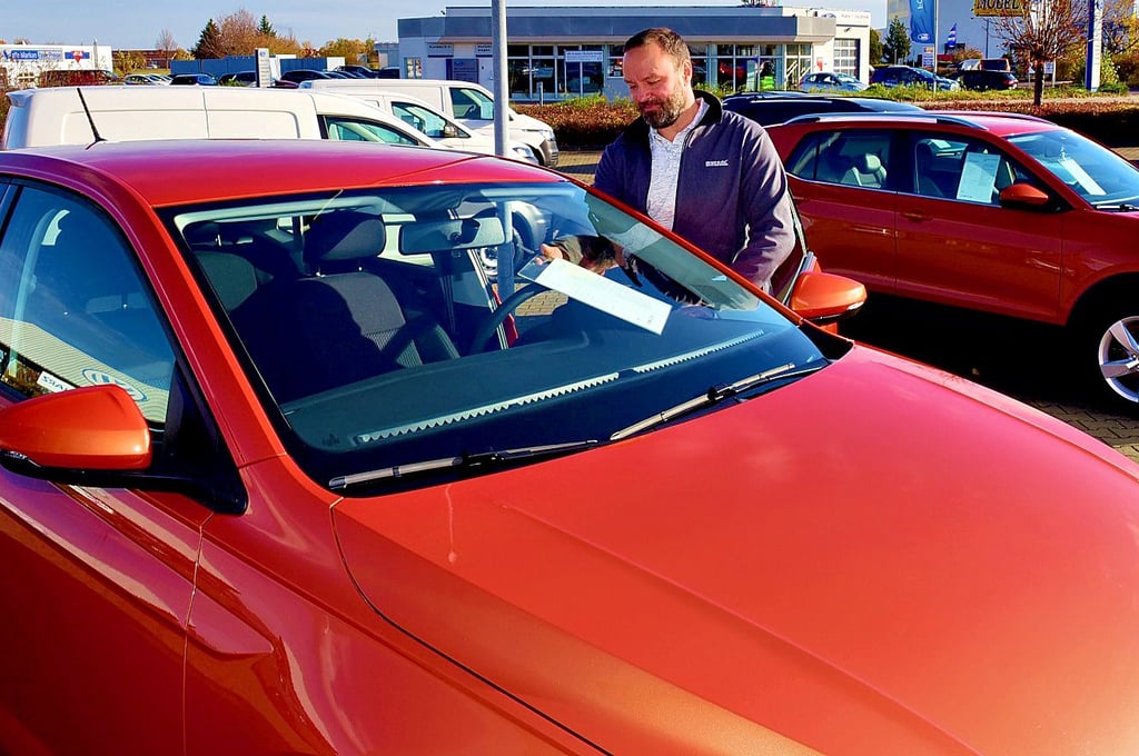 Autohaus-Geschäftsführer Sven Albrecht an einem Gebrauchten.