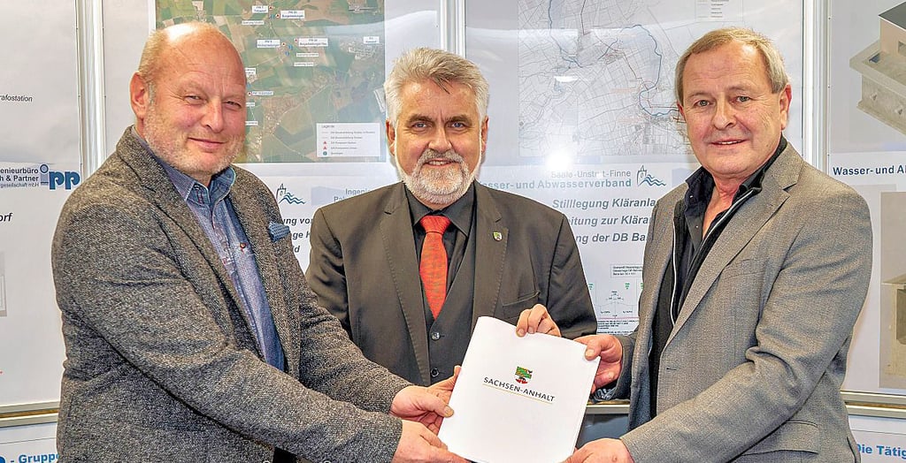 Armin Willingmann (M.) übergibt Geschäftsführer Michael List (r.) und Verbandsvorsitzenden Olaf Schumann den Fördermittelbescheid.