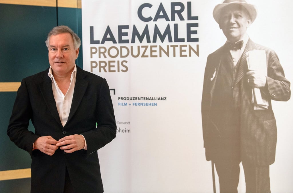 Nico Hofmann neben einem Porträt von Carl Laemmle.