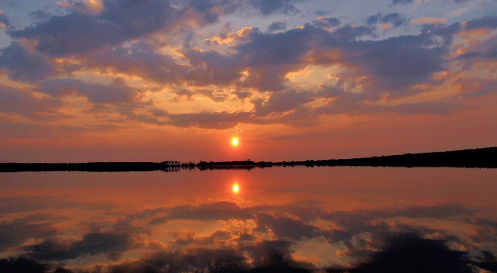 Sonnenuntergang am Arendsee: Der Himmel spiegelt sich auf der Wasseroberfläche. Ob irgendwann dort auch Solarmodule zu sehen sind, ist derzeit völlig offen. In anderen Regionen gibt es solche Anlagen auf Gewässern aber bereits.