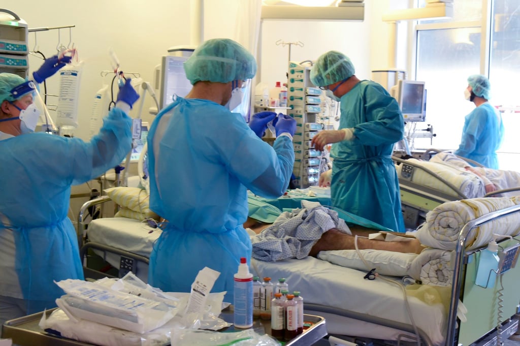 Auf der Covid-Station vom Universitätsklinikum Leipzig versorgen Ärzte, Schwestern und Pfleger einen Patienten.