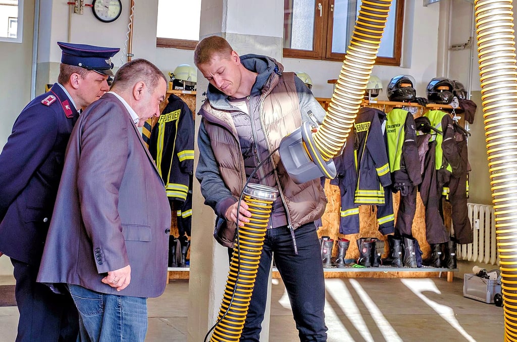 Mithilfe dieses langen Schlauchs können die Abgase über eine Rohrleitung nach draußen transportiert werden. Marc Bubig, Sponsor der Anlage und Geschäftsführer der Firma „Lewesh“ gibt eine kurze Einweisung.