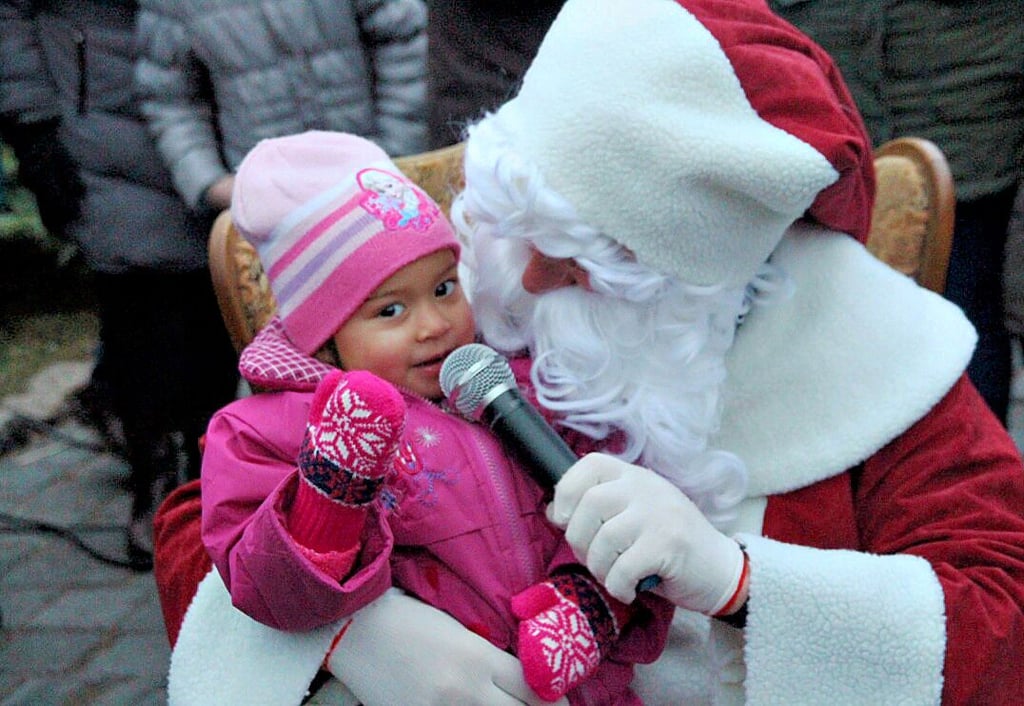 Der Weihnachtsmann nimmt im Dezember 2018 auf dem Adventsmarkt in Gladigau ein Kind auf den Schoß. Den Gladigauer Budenzauber soll der Weißbart auch in diesem Jahr ansteuern. Das Dorf hält an seinen Adventsmarktplänen fest.