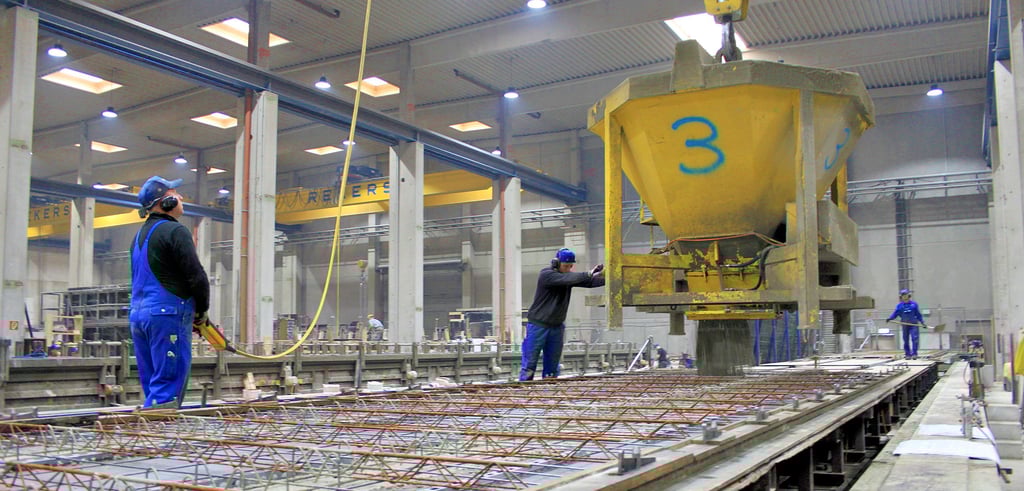 Mittels riesiger Trichter wird der fertige Beton in die vorgesehen Form verfüllt. Hier entsteht gerade eine Deckenplatte.