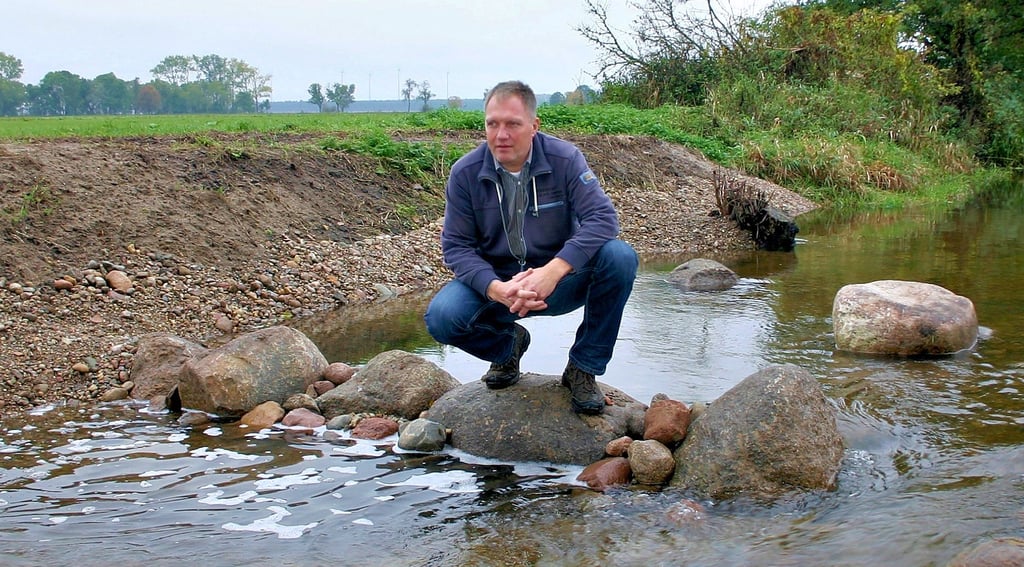 Jan Klein, Geschäftsführer des Unterhaltungsverbandes „Tanger“, zeigt, wie im Uchtdorfer Mühlengraben der Wasserfluss auf natürliche Weise reguliert werden kann.