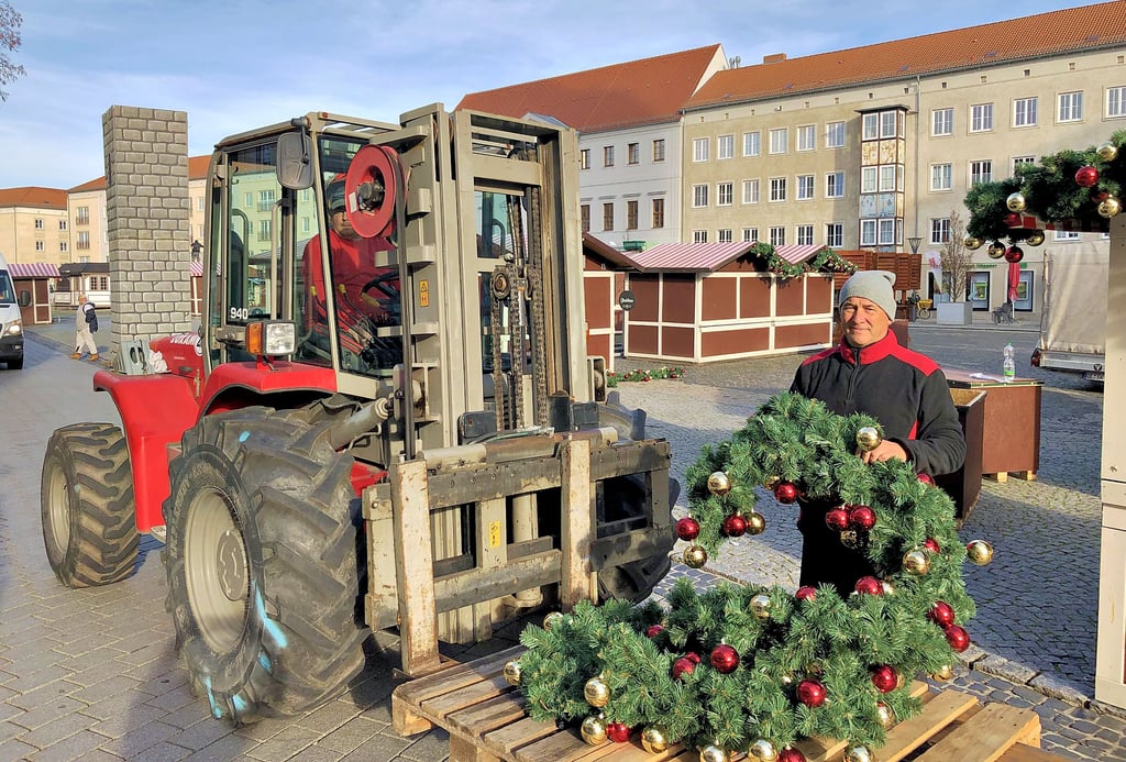 Weihnachtsmarktveranstalter Dirk Merkel (r.) packt beim Aufbau auch selbst mit an.