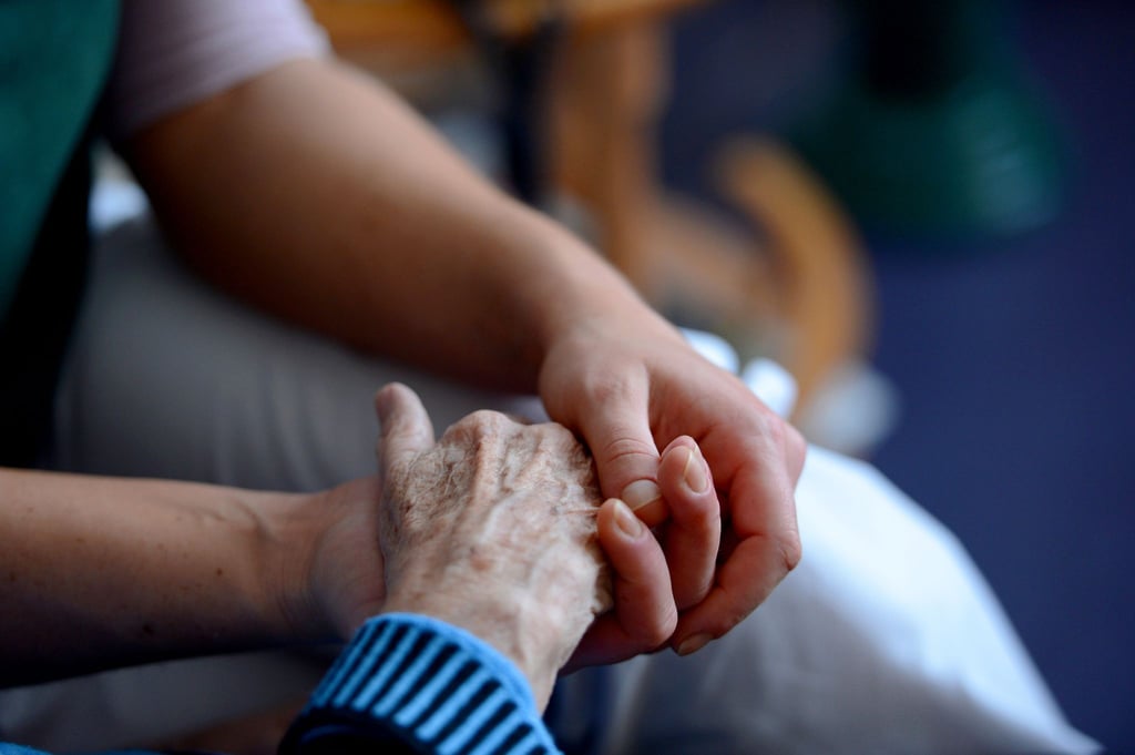 Ein Mann hält die Hand einer älteren Frau. Laut einer Umfrage würden zwei Drittel der 16- bis 39-Jährigen ihre Familienangehörigen pflegen.