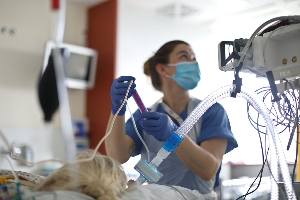 Intensivpflegerin am Bett einer Patientin.