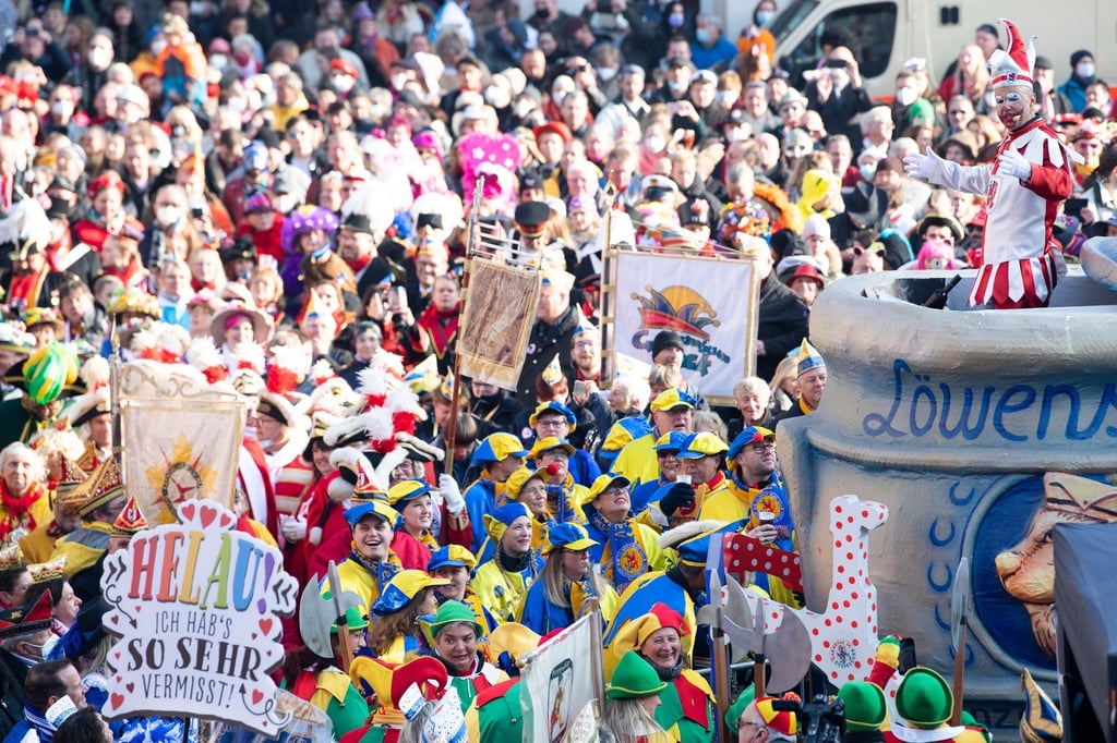 Menschenmassen jubeln dem Düsseldorfer Hoppeditz (r) zu.
