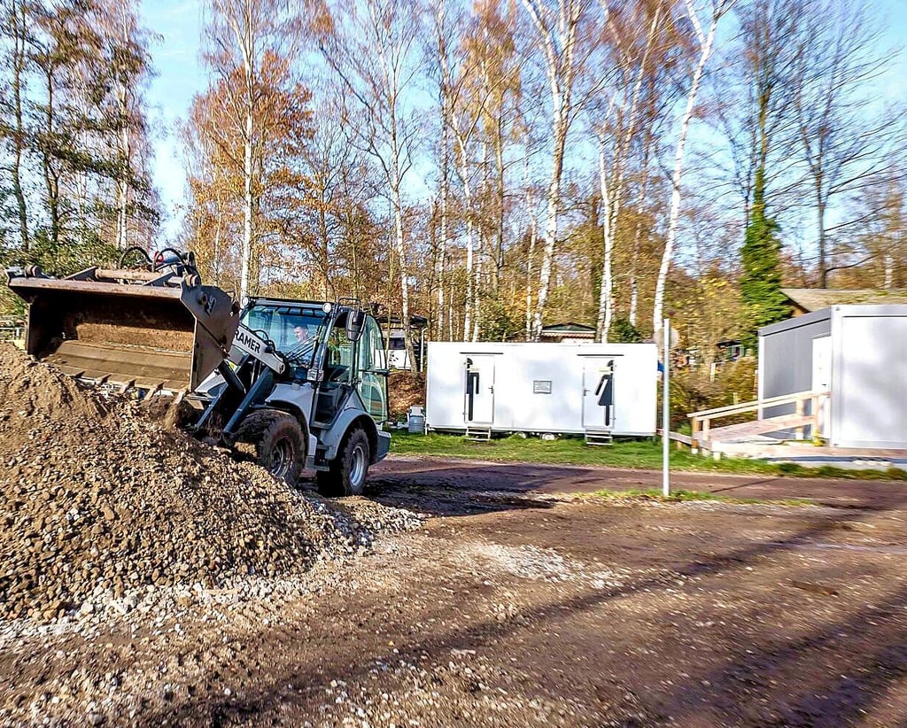 Es geht voran auf der Baustelle: Die Container mit Duschen und Toiletten im Hintergrund dienen als vorübergehende Lösung.