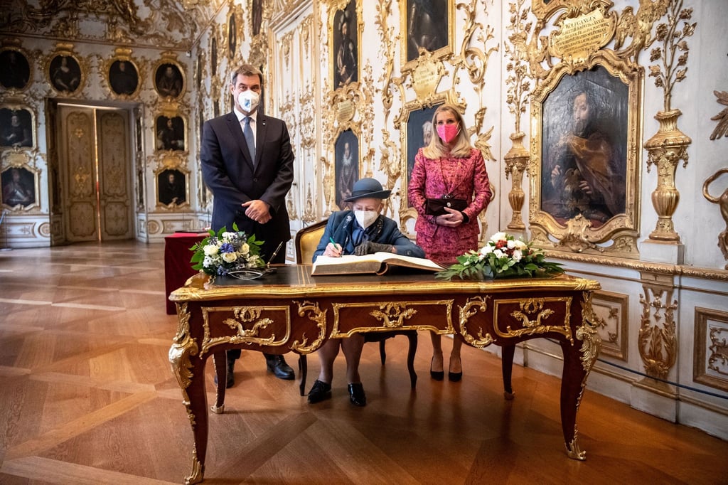 Königin Margrethe II. von Dänemark (M) trägt sich in der Residenz München in das Gästebuch der Bayerischen Staatsregierung ein. Neben ihr: neben Markus Söder (CSU), Parteivorsitzender und Ministerpräsident von Bayern, und seine Frau Karin Baumüller-Söder.