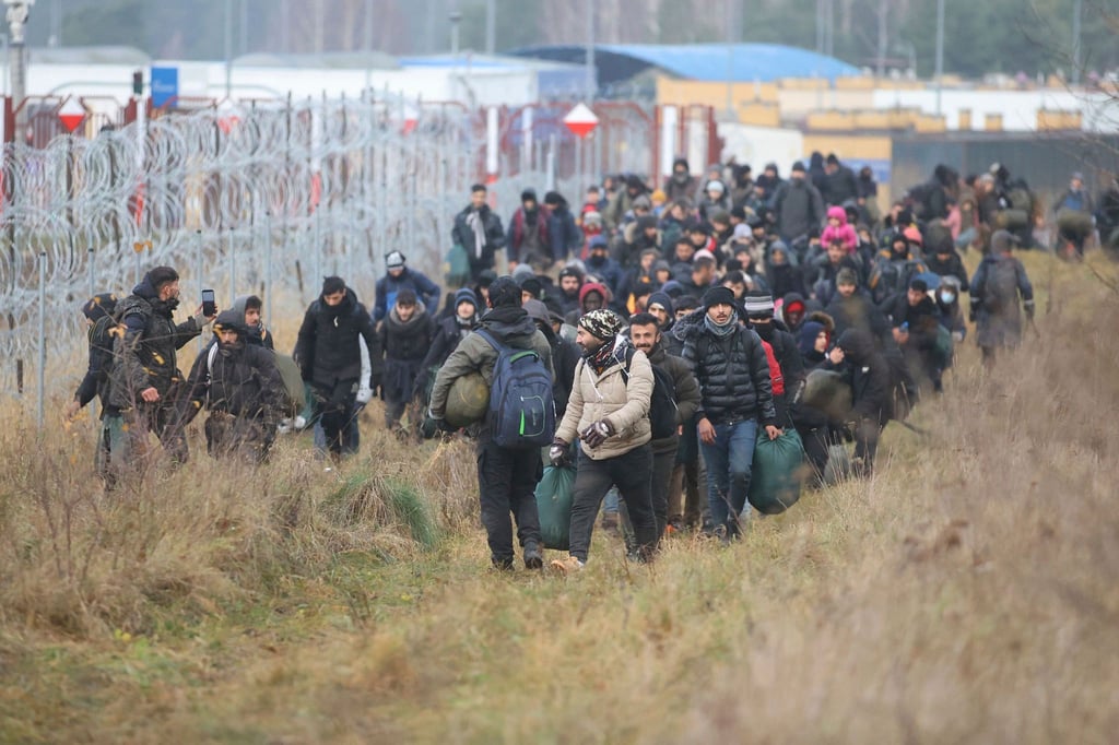 Migranten am Stacheldrahtzaun an der belarussisch-polnischen Grenze.