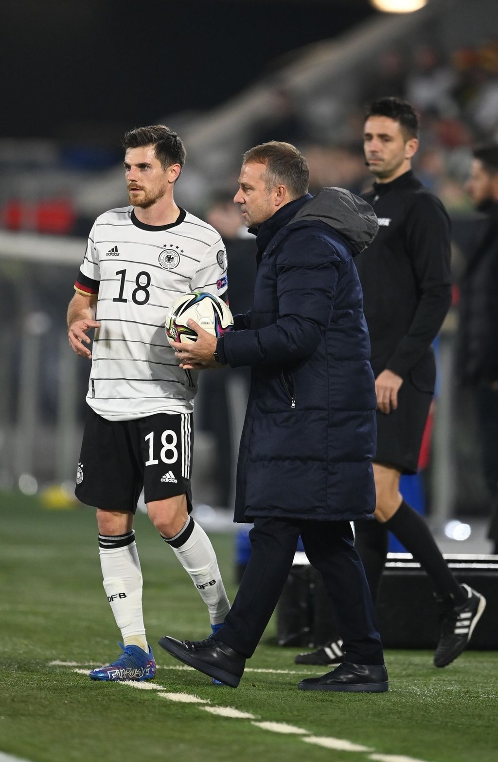 Bundestrainer Hansi Flick (M) gibt Jonas Hofmann den Ball und Anweisungen.